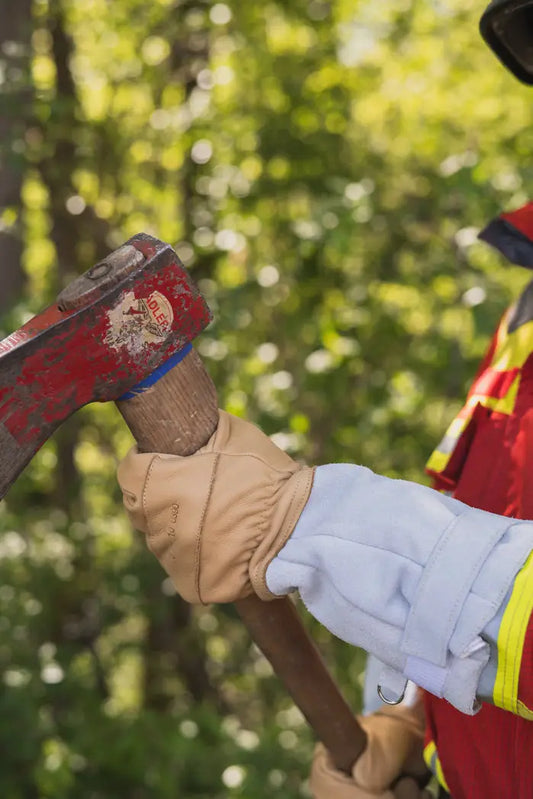 Roter Hammer in glatten Feuerwehrhandschuhen für extreme Temperaturen beim Innenangriff