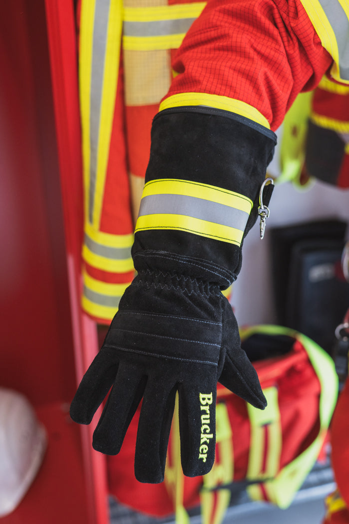 Rechter Handrücken des Handschuhs S Black mit gespreizten Fingern an einer Person vor Feuerwehrgarderobe