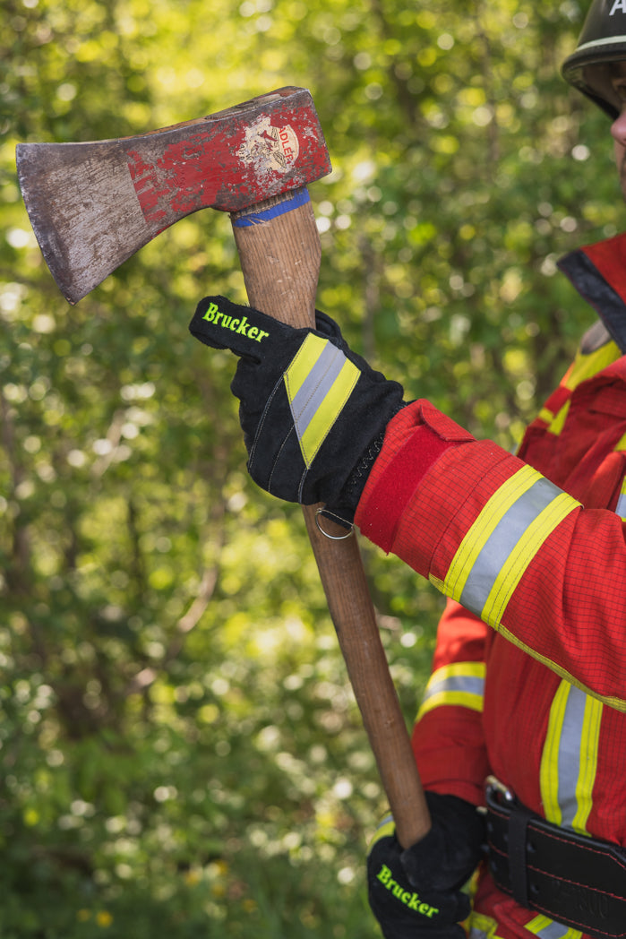 Feuerwehrmann hält mit Feuerwehrhandschuhen Black eine Axt
