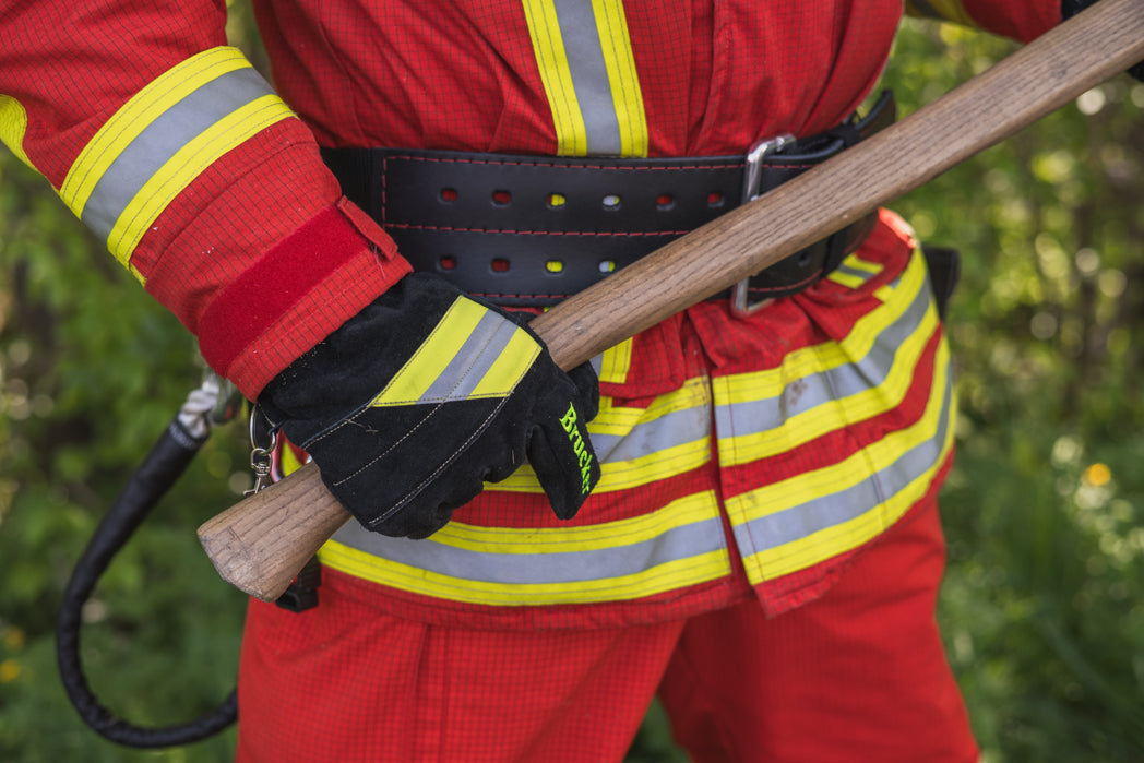 Feuerwehrmann hält mit rechts mit Feuerwehrhandschuhen Black einen Axtstiel am unteren Ende