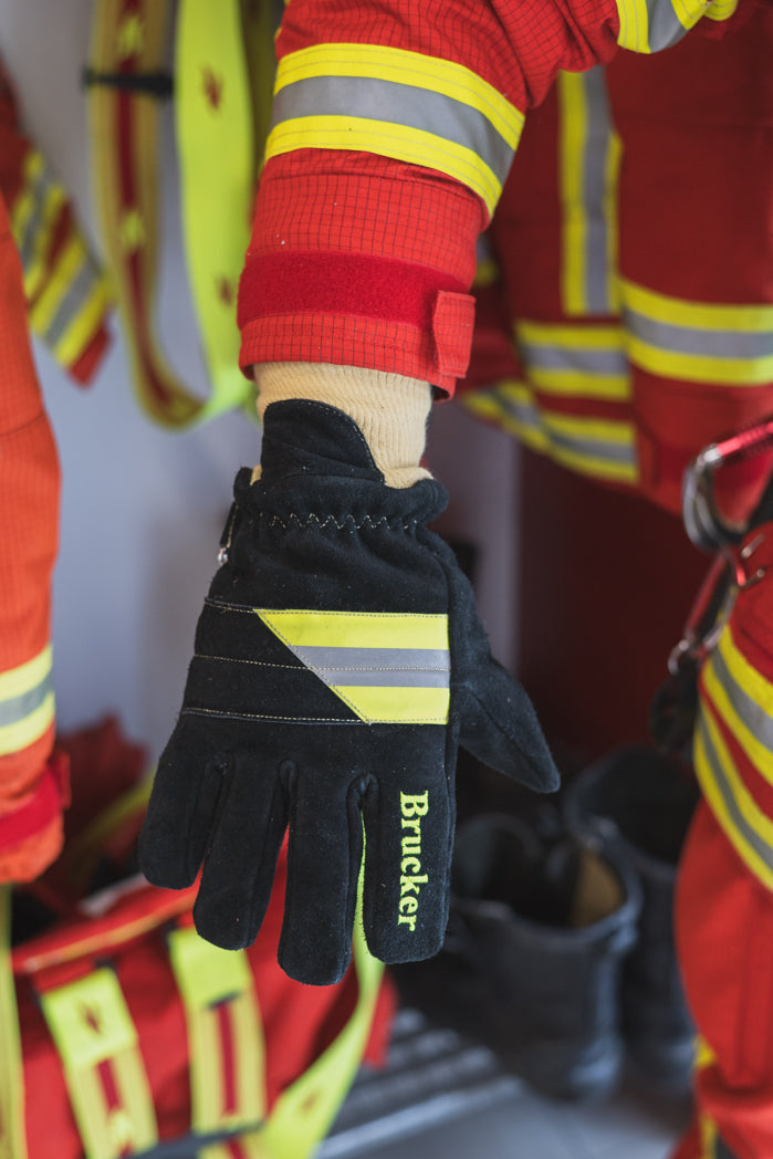 Rechter Handrücken des Handschuhs Black mit gespreizten Fingern an einer Person vor Feuerwehrgarderobe