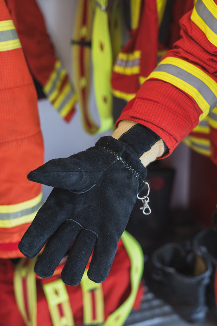 Innenhand des Handschuhs Black an einer Person vor Feuerwehrgarderobe